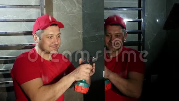 一个男人一个建筑工人穿着红色的帽子和t恤使用无绳螺丝刀视频的预览图