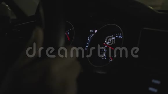 一个汽车仪表盘的特写而男子开车到城市街道在夜间视频的预览图