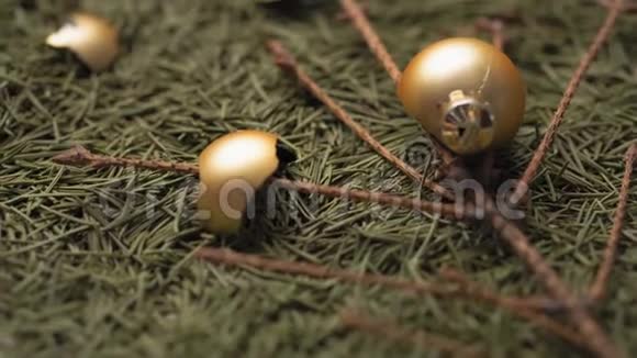 破碎的金色圣诞球躺在干燥的落针和圣诞树的树枝上视频的预览图