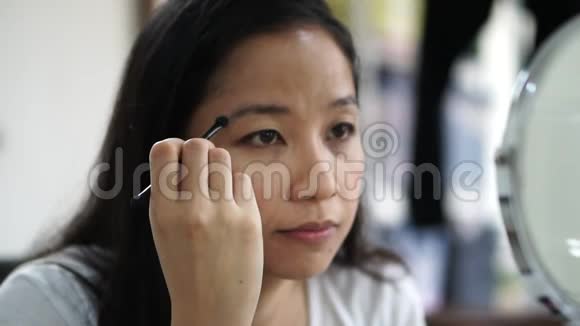 美丽的中年亚洲女人做眉毛补刷常规基础视频的预览图