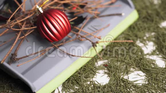 用一个灰色的铲子在一张桌子上用倒下的松针特写了破碎的圣诞球和干松枝视频的预览图