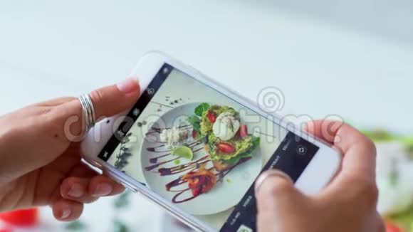 女性用现代智能手机拍照食物特写镜头4K视频的预览图