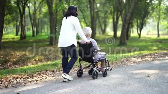 亚洲老年或老年妇女在公园度假时在轮椅上得到照顾帮助和支持健康强壮的医疗视频的预览图