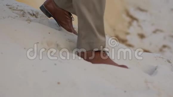 穿着鞋子在沙滩上行走的男女特写镜头视频的预览图