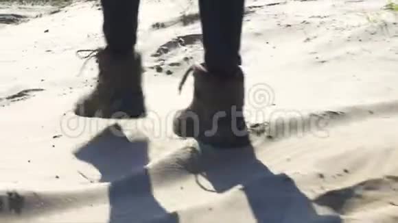 女人的脚和女徒步旅行者的鞋子在沙滩上行走视频的预览图