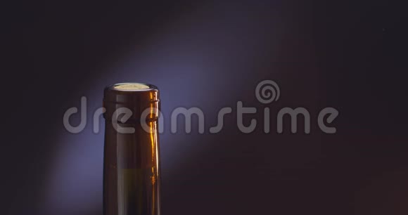 一个拿着开瓶器的人在黑色背景上打开一瓶酒视频的预览图