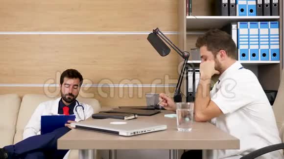 两位医生在现代舒适的办公室里互相交谈视频的预览图