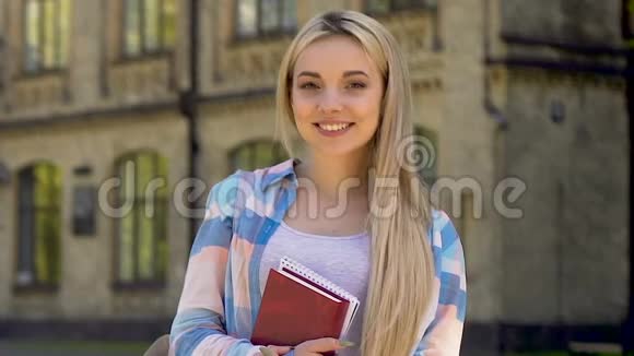 在镜头前微笑的金发女孩成功的学生有前途的职业机会视频的预览图