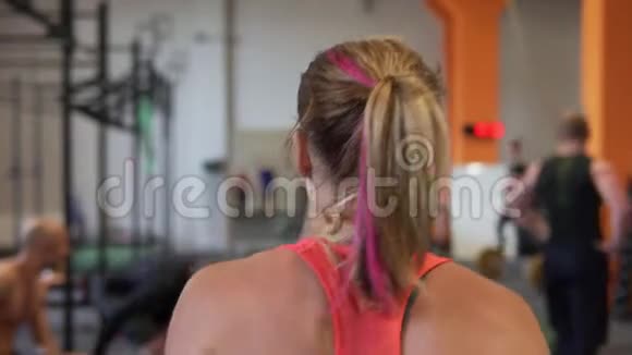 肌肉健康女性在健身房散步后视图视频的预览图