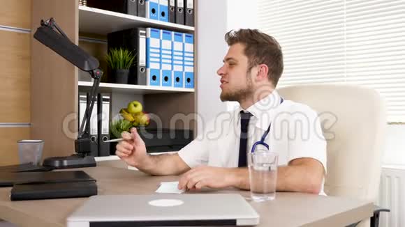 办公室的办公桌上的医生在和他的同事说话微笑着视频的预览图