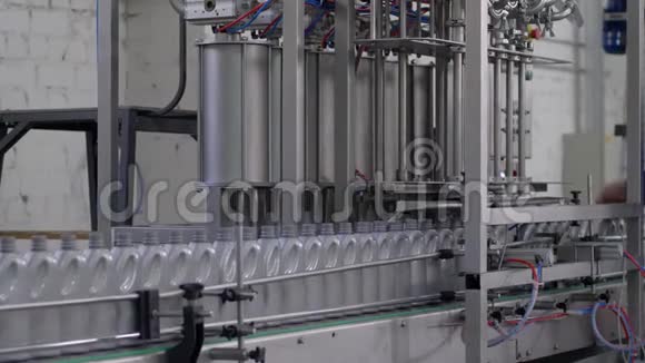 生产电机油工厂移动输送线上的一排灰色塑料瓶视频的预览图