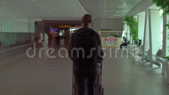 一名戴医药面具的年轻女子在一个机场用一只手托洛普利视频的预览图