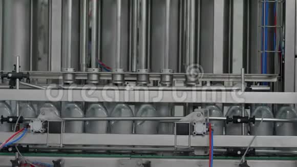 工厂生产线设备将发动机液体合成油倒入灰色塑料瓶视频的预览图