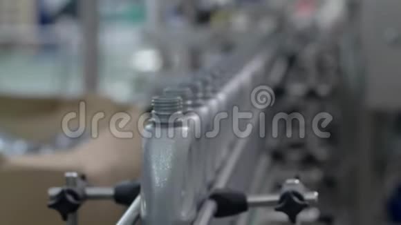 汽车工业工厂工人把灰色塑料瓶排在移动的输送线上视频的预览图