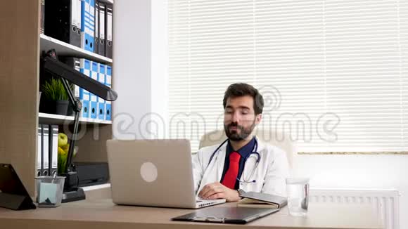 医生在办公室的办公桌前看着手表等待化验结果视频的预览图