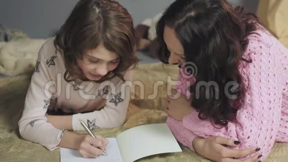 女儿做家庭作业和母亲谈论上学的日子家庭视频的预览图