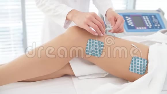 美容店里一个身材苗条的女人的腿和臀部受到肌刺激视频的预览图
