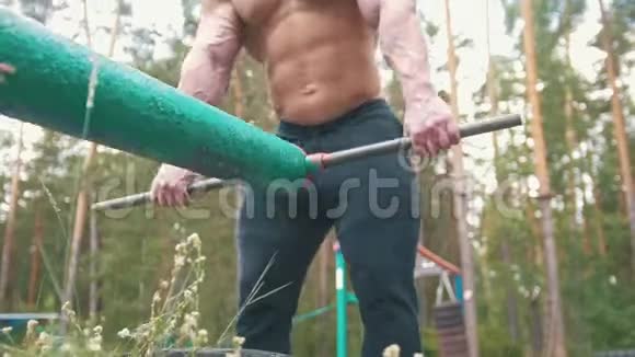 肌肉健美运动员在森林户外使用大型重铁设备锻炼身体视频的预览图
