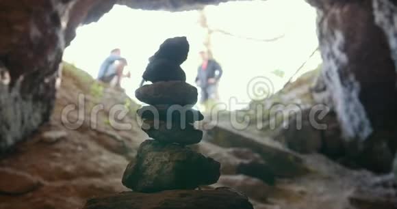 在一群地质学家前面的小石塔下到洞穴视频的预览图