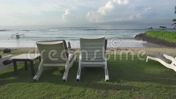 太阳床在空的热带海滩岸边在一个低季节海中大风和病浪天空中的太阳视频的预览图