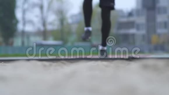 男子脚在沙滩上跳户外跳高腿在沙滩上跳运动场健康生活方式视频的预览图