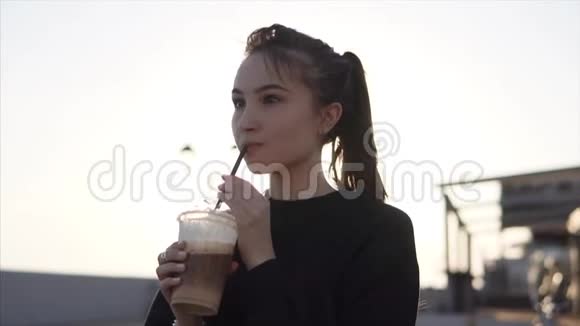 快乐的少女晚上在街上喝着冷咖啡视频的预览图