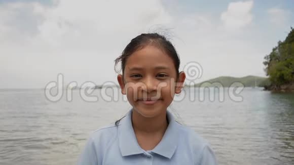 特写可爱女孩在海滩上微笑的肖像视频的预览图