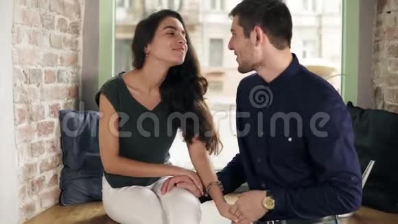 爱的男人和女人在咖啡馆里牵手微笑着浪漫的情侣在咖啡馆里聊天牵手视频的预览图
