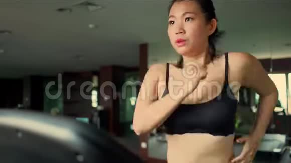 年轻有魅力可爱的亚洲女性在酒店健身房或健身俱乐部跑步锻炼在跑步机上艰苦训练视频的预览图