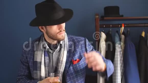 穿着时尚西装戴着帽子的优雅男子摆着饮料摆在阿特尔耶视频的预览图