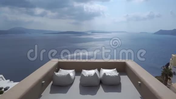 在希腊的奥亚圣托里尼大沼泽地的悬崖上粉刷房屋和教堂可以看到海景和日光浴视频的预览图