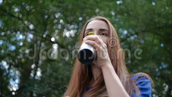 女孩慢吞吞地喝着咖啡脸上带着一个热杯子视频的预览图