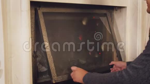 4k视频年轻人在家里壁炉里扔木头视频的预览图