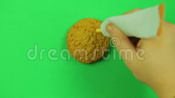 一个孩子在饼干美元标志上画了一个绿色背景的焦糖糖霜时光飞逝视频的预览图