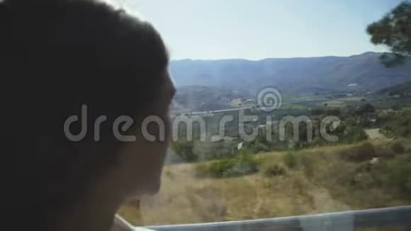 女孩透过公共汽车车窗观看风景的特写肖像视频的预览图