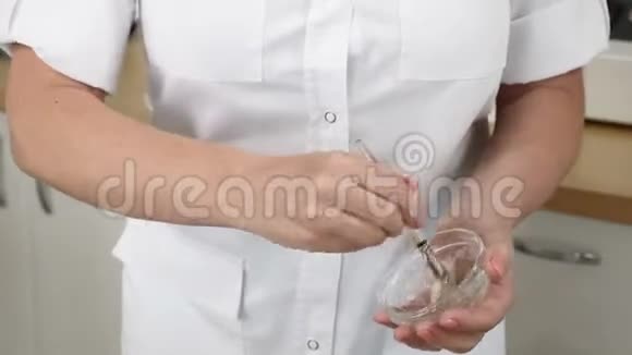 美容中心医生准备面膜用刷子搅拌玻璃碗中的成分关门视频的预览图