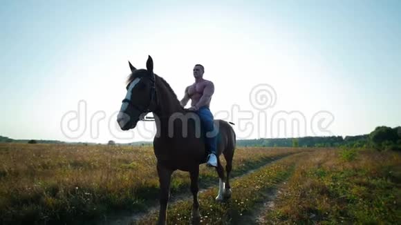夏天壮汉骑着一匹马在田野的中央顶着太阳视频的预览图