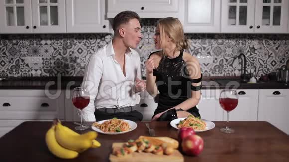浪漫情侣在厨房餐桌上吃意大利面视频的预览图