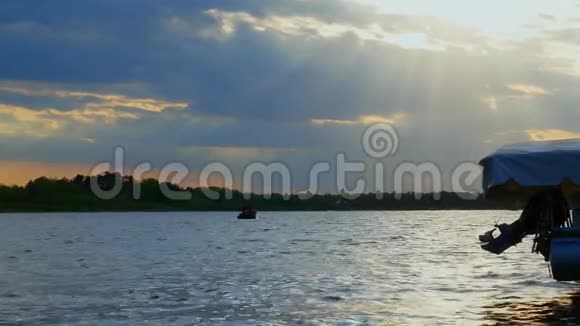 日落时在湖上渔船上的渔民剪影视频的预览图