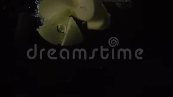慢动作镜头一片片绿苹果落在水中漂浮黑色背景食物视频视频的预览图