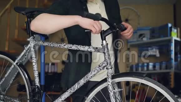 年轻人自行车修理工用工具修理现代自行车的坏车把维修周期熟练视频的预览图