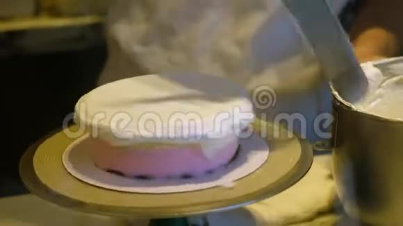 厨师在蛋糕上用刀涂抹奶油视频的预览图