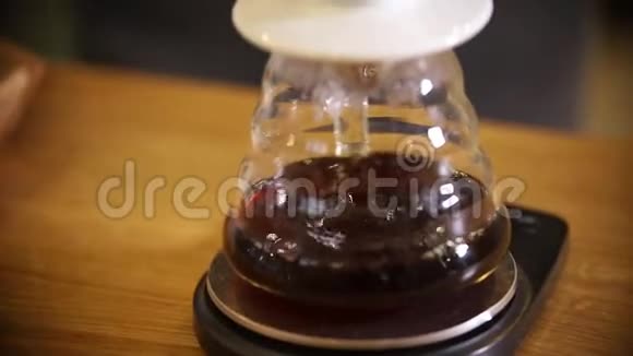 咖啡师用漏斗制作美式咖啡一个美国人通过过滤器倒在茶壶里视频的预览图