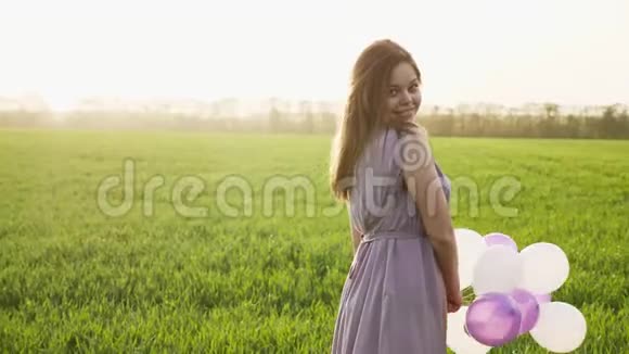 可爱的黑发女孩走在春天的麦田里视频的预览图