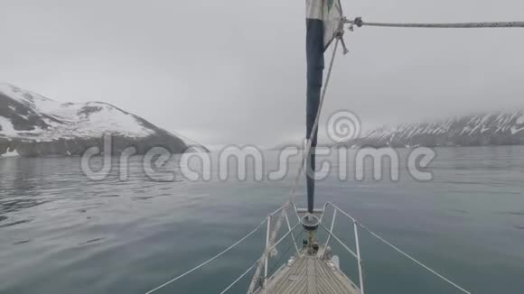 从雪山上航行的船头船和海上的悬崖景观看视频的预览图