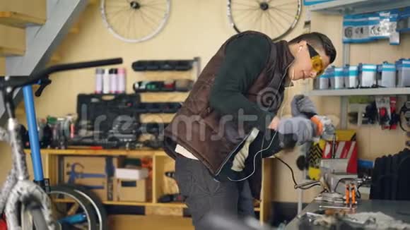 集中机修工正在舒适车间的工作台上用电动圆锯锯切金属零件自行车视频的预览图