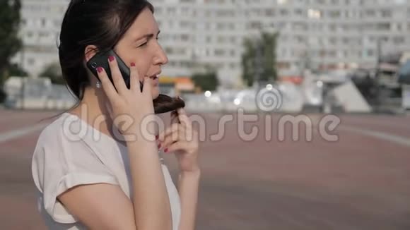 街上一个黑发女人边说话边掉电话视频的预览图