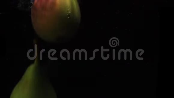 三个梨落在水中溅起的水花和气泡在缓慢的运动视频的预览图