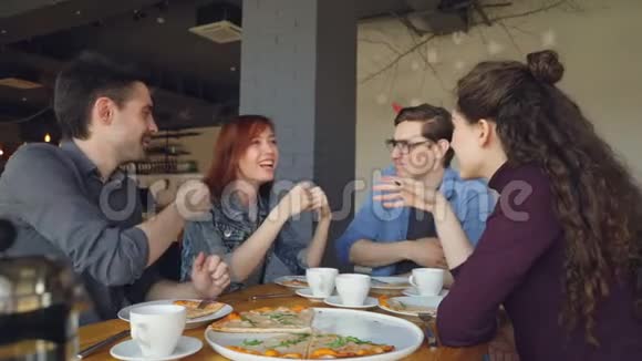 亲密的朋友正在分享有趣的故事在现代咖啡馆吃午饭时打手势和大笑积极情绪视频的预览图