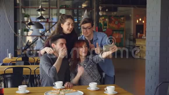 最好的朋友正在自拍笑着摆姿势做有趣的脸在咖啡馆的午餐拥抱手势社会媒体视频的预览图